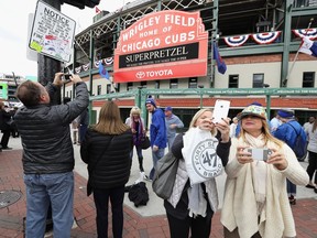 Fans take photographs outside of Wrigley Field, where Game 3 of the World Series was to be played Friday. They probably couldn't afford to get inside.