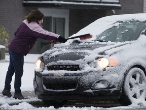 SASKATOON,SK-- October 05/2016  1006 news weather --- A heavy, wet snow from a major weather system  left Saskatoon residents like Lauren Vaillant cleaning their cars and driving in slippery conditions, Wednesday, October 05, 2016.  Intermittent power outages affected traffic lights and created backups. (GREG PENDER/STAR PHOENIX)