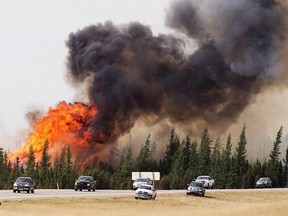 A convoy of evacuees from Fort McMurray, Alberta drive past wildfires on Saturday, May 7, 2016. THE CANADIAN PRESS/Ryan Remiorz