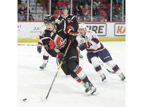 Moose Jaw Warriors forward Nikita Popugaev moves up ice as Regina Pats forward Adam Brooks gives chase.