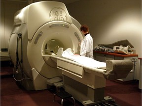 A technician operates an MRI machine at a private clinic in Calgary. The federal Liberals say Saskatchewan's use of private MRI facilities might violate the Canada Heath Act.