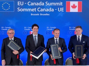 Let's make a deal: (LtoR) European Commission President Jean-Claude Juncker, Canadian PM Justin Trudeau, European Council President Donald Tusk and Slovakian Prime Minister Robert Fico, at the signing of the CETA trade deal in Brussels.