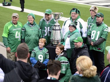 Fans pose with the Grey Cup at the last CFL game at old Mosaic Stadium in Regina, Sask. on Saturday Oct. 29, 2016. MICHAEL BELL