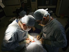 Surgeons at work in the Queen Elizabeth Hospital in Birmingham, U.K. More than 80 per cent of health funding in the U.K. comes from government.