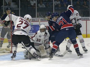 Regina Pats forward Dawson Leedahl (71) tries to get the puck past Red Deer Rebels goalie Lasse Petersen and defenceman Jared Freadrich (27) during a WHL game held at the Brandt Centre on Sunday.