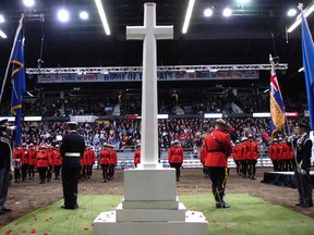 Poppies surround a cross at a Remembrance Day ceremony attended by thousands in the Brandt Centre in Regina in 2013.