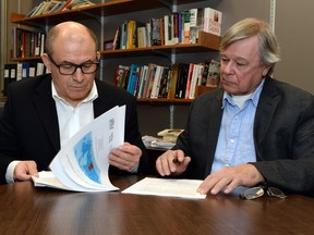 Miguel Sanchez (left) and Paul Gingrich look over the report they co-authored along with Garson Hunter (not pictured).