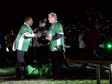 REGINA, SASK :  October 29, 2016  -- Roughriders legend George Reed, left, hands the Grey Cup to Roger Aldag during the post game show following the Saskatchewan Roughriders final home game at old Mosaic Stadium in Regina. TROY FLEECE / Regina Leader-Post