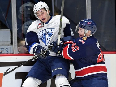 Regina Pats, Riley Bruce (R) hammers Josh Paterson with the Saskatoon Blades during a Western Hockey League game against the Saskatoon Blades at the Brandt Centre in Regina.