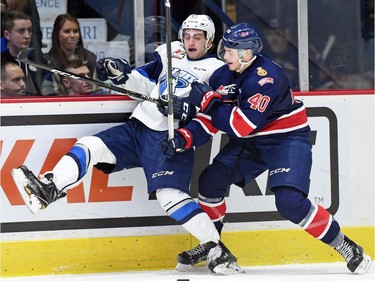 Regina Pats, Riley Bruce (R) hammers Josh Paterson with the Saskatoon Blades during a Western Hockey League game against the Saskatoon Blades at the Brandt Centre in Regina.