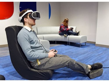 Brad Louttit (L) plays Playstation VR at the rebuilt George Bothwell branch public library in the Southland Mall in Regina.