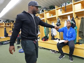 Saskatchewan Roughriders quarterback Darian Durant, left, fist-bumps with receiver Phil Bates during the team's annual locker-room clean-out at Mosaic Stadium on Sunday.