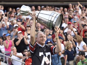 Ottawa Rough Riders legend Tony Gabriel carries the Grey Cup on to the field on July 31 at TD Place.