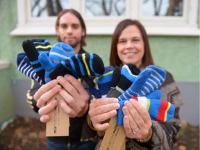 Tyler Marin and Jade Lea-Wilson hold up new mittens outside of Lea-Wilson's home in Regina, Sask. on Sunday Nov. 27, 2016. Marin, Lea-Wilson and seven other Saskatchewan Polytechnic entrepreneurship students formed a business project called Mismatched Mittens, whose goal is to raise awareness and money for the Red Cross's Stand Up to Bullying Campaign.