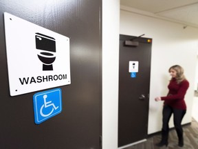 A woman walks to a bathroom at the Prairie Valley School Division office in Regina, Saskatchewan on Dec. 6, 2016. All the bathrooms of the rural school division's 39 schools now have gender neutral signage, what they call "all gender bathrooms."