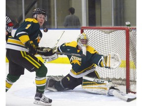 Cougars goalie Dawson MacAuley (31) and teammate Tyler King (7) both eye a rebounded puck during Saturday's 7-2 loss to the visiting University of Lethbridge Pronghorns at the Co-operators Centre.