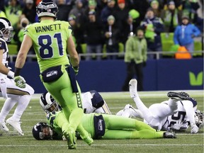 Seattle Seahawks punter Jon Ryan, lower left, lies on the turf after taking a hard hit while running the ball on a fake punt play against the Los Angeles Rams in the second half of an NFL football game, Thursday, Dec. 15, 2016, in Seattle. Ryan left the game with an injury on the play.