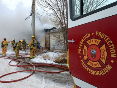 Regina Fire and Protective Services members deal with a garage fire at 1454 Edward St. in Regina, Saturday.