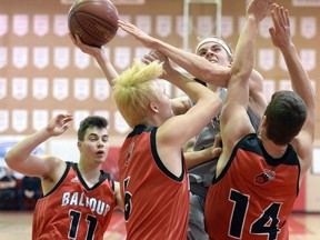 Damon Dutton of the North Battleford Vikings drives hard to the net against John MacMurchy (left) and Randy Orchard (right)  of the Balfour Bears during the 28th annual Fekula Classic on Friday.