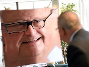 Ralph Goodale, Federal Minister of Public Safety and Emergency Preparedness stares into a special mirror used to detect UV light and investigate proton structure during a news conference at the University of Regina announcing funding for particle physics equipment for the university.