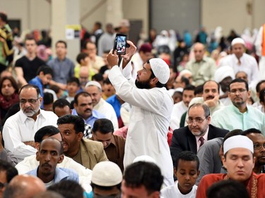A member of the Muslim community videos the crowd gathered before prayer to mark the end of Ramadan and the start of the holiday Eid-ul-Fitr at the Canada Centre Building in Evraz Place in Regina. In the past there have been more than 7,000 people attend the prayer