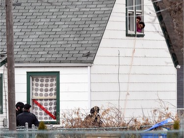 People stick their heads out of a second floor window of a house in the 1100 block of McTavish Street under surveillance by police. The Regina police SWAT team, crisis negotiators and the explosives disposal unit were called Wednesday morning to the house on 1100 McTavish Street to deal with a suspect reported to have barricaded himself inside.  Police blocked off about a six-block perimeter in the area that included the 1000 to 1200 blocks of Argyle and Princess Streets.