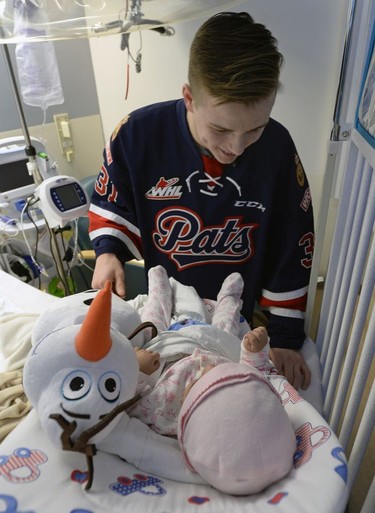 Members of the Pats  including Tyler Brown were presenting their teddy bears collected during the Teddy Bear Toss at last Friday's game to kids at the Regina General Hospital. Here Brown gives a stuffed toy to newborn Zainab Taqvi.