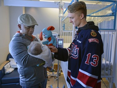 Members of the Pats including Riley Woods were presenting their teddy bears collected during the Teddy Bear Toss at last Friday's game to kids at the Regina General Hospital.  Here Woods meets newborn Deo Guarin and dad JR Guarin.