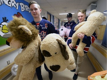 Members of the Pats  including Captain Adam Brooks Riley Woods and Chase Harrison were presenting their teddy bears collected during the Teddy Bear Toss at last Friday's game to kids at the Regina General Hospital.