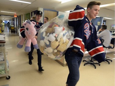 Members of the Pats  including Tyler Brown (front) and Chase Harrison were presenting their teddy bears collected during the Teddy Bear Toss at last Friday's game to kids at the Regina General Hospital.