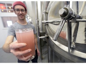 Adam Smith holds a glass of nearly-ready cranberry mead at Malty National microbrewery.