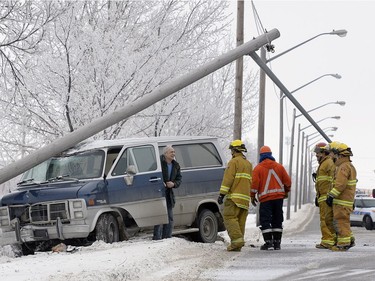 The driver of this van (left) wisely stayed inside until he was told it was safe to exit after sliding into and breaking off a power pole on Ross Ave. east of McDonald Street over the lunch hour Wednesday. He was not hurt in the crash.
