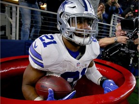 Ezekiel Elliott of the Dallas Cowboys celebrates a touchdown by jumping into a Salvation Army red kettle during an NFL game on Sunday.