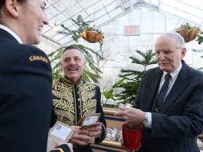 Callista Szachury, left, laughs while receiving a Canada 150 tulip bulb from Gerard St. Godard, center left, and Vincent Murphy, right, during New Year's Day Levee held at Government House.