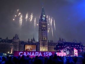 Fireworks explode behind the Peace Tower during a celebration on Parliament Hill on New Year's Eve, Saturday, Dec. 31, 2016 in Ottawa. Canada celebrates its 150th anniversary of Confederation in 2017.