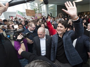 Prime Minister Justin Trudeau makes his way through the crowds as people hold oil pipeline protest signs at the University of Regina on Thursday January 26, 2017.