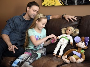 Ken Zech watches his seven-year-old daughter Arianna give her doll a finger prick blood glucose test. Arianna has Type 1 diabetes.