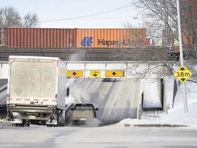 A large commercial truck heads northbound on Winnipeg Street under the underpass between Dewdney Avenue and 8th Avenue in Regina.