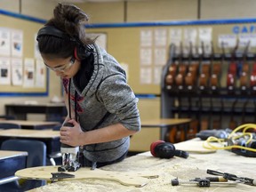 Grade 7 student Brailyn Duckworth cuts a boot hole in her plywood snowshoes at Centennial School.