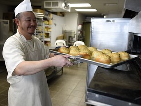 Chef Tony Wong pulls a tray of baked buns from the oven at China Pastry.