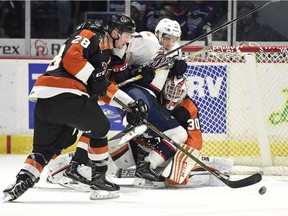 Regina Pats forward Dawson Leedahl tries to break through a pair of Medicine Hat Tigers' defenders as well as goalie Michael Bullion during WHL action at the Brandt Centre on Friday.