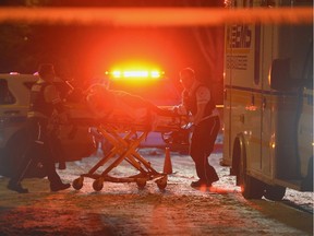 Paramedics move a man from a house to an ambulance at 919 Shannon Road.