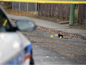 Regina police officers attend to the scene of a homicide in the 500 block of Montreal Street on Nov. 1, 2013. Evidence markers can be seen in the background.