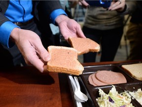 Drew Wilby, with Corrections, displays the exact meal prepared for inmates for lunch at the Regina Provincial Correctional Centre in Regina on Jan. 7, 2016. The bread he's holding is covered in a peanut butter-jelly mix.