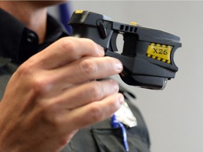 A Regina Police Service member holds up a Taser.