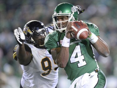 Saskatchewan Roughriders quarterback Darian Durant runs with the ball as he is rushed by Hamilton Tiger-Cats defensive lineman Torrey Davis during fourth quarter of the Grey Cup, Sunday, November 24, 2013 in Regina.