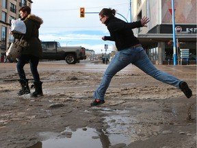 Commuters had to leap over muddy slush puddles as they crossed the streets downtown Saskatoon during the warm winter weather on January 18, 2017.