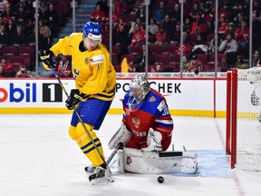 Goaltender Ilya Samsonov of Team Russia makes a pad save while being screened by Filip Ahl of Team Sweden during the world junior bronze-medal game at the Bell Centre in Montreal.