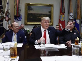 President Donald Trump, centre, and Commerce Secretary-designate Wilbur Ross, left, talk to media before a lunch meeting in the Roosevelt Room of the White House in Washington, Thursday, Feb. 2, 2017.