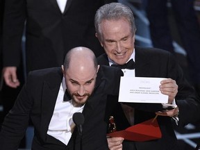 Jordan Horowitz, producer of &ampquot;La La Land,&ampquot; shows the envelope revealing &ampquot;Moonlight&ampquot; as the true winner of best picture at the Oscars on Sunday, Feb. 26, 2017, at the Dolby Theatre in Los Angeles. Presenter Warren Beatty looks on from right. (Photo by Chris Pizzello/Invision/AP)